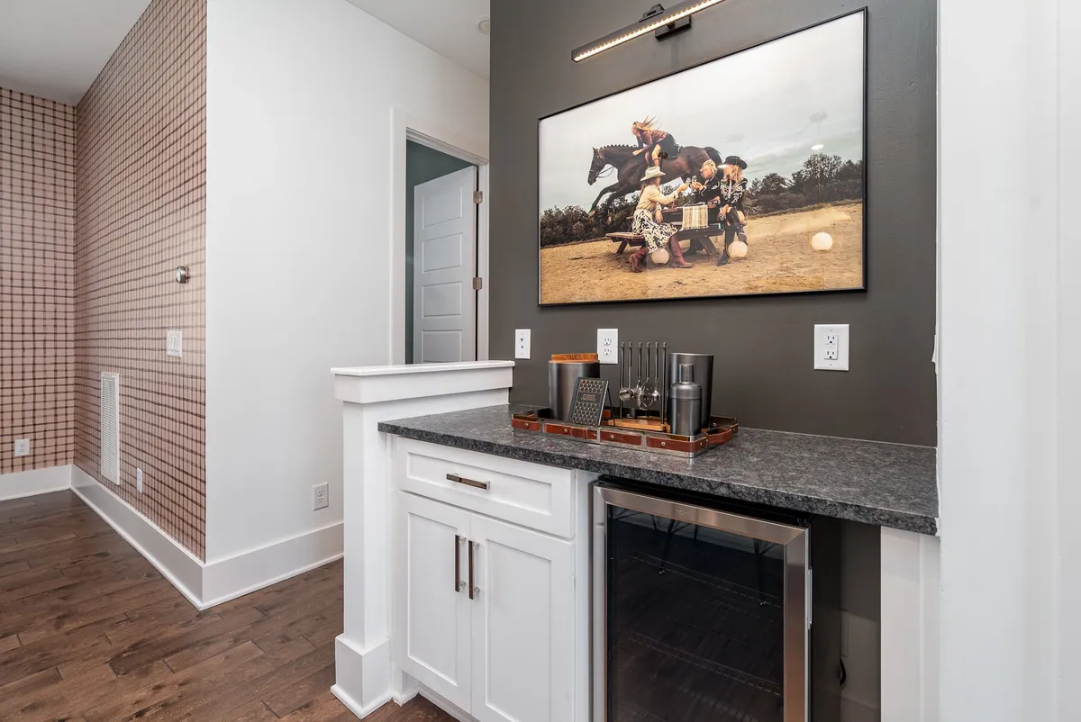 A chic bar area with modern cabinetry, stylish artwork, and a dedicated counter space for mixing drinks. This cozy nook is designed for preparing and enjoying cocktails in an intimate setting.